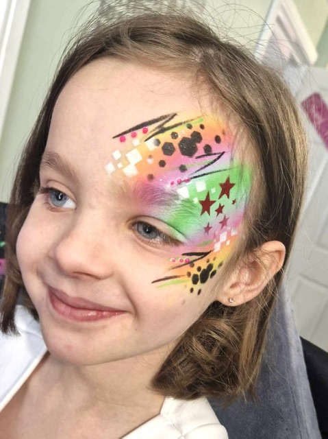 girl with her face painted bright colours in Telford